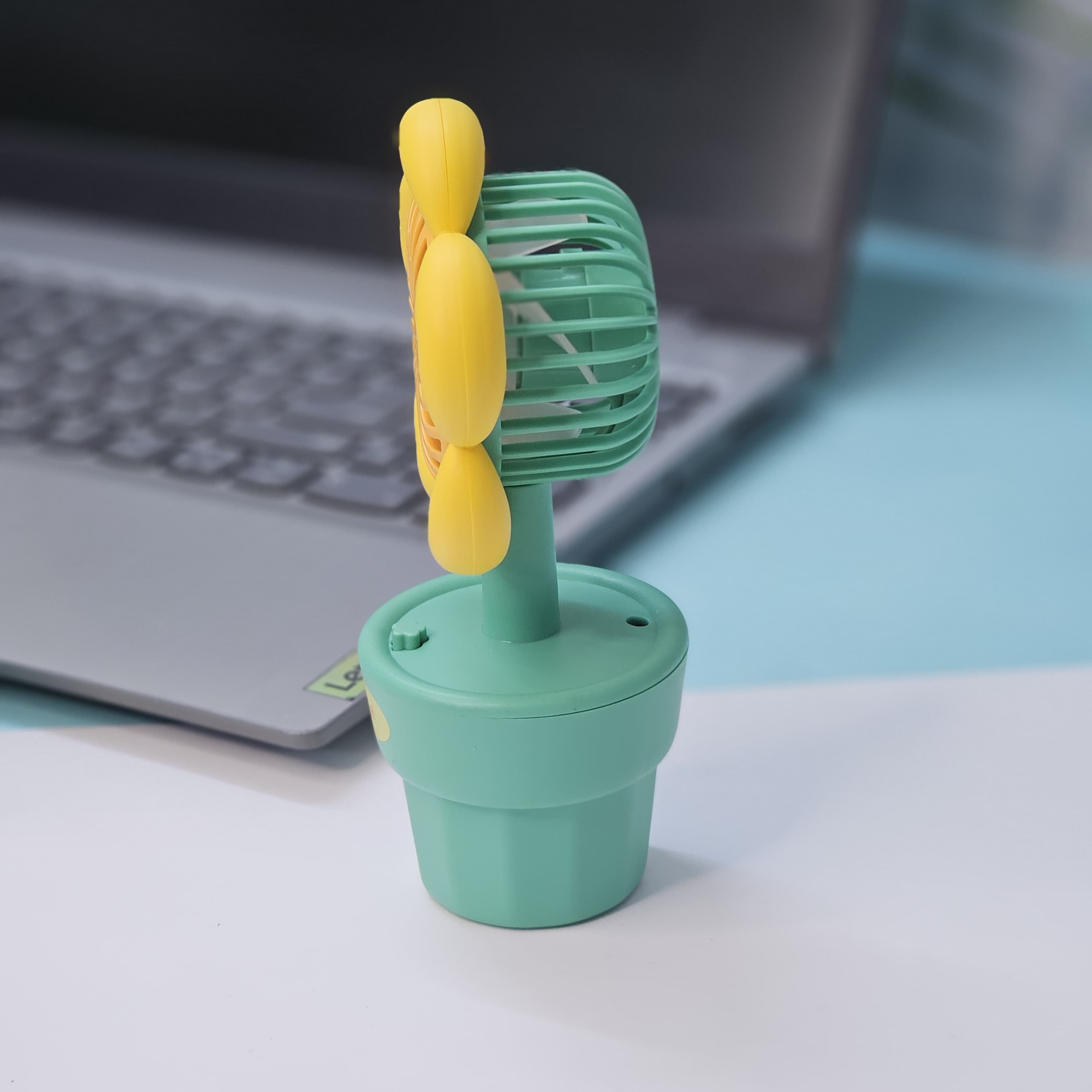 Usmile Toys 'Mini Desk Fan for Kids': an adorable flower-designed fan in yellow, purple, and pink, providing a gentle breeze as a cute desktop accessory."www.usmile.toys